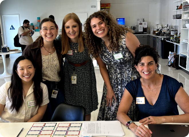 a woman and a man helping each other attaching a post-it to the glass wall in a brainstorm session